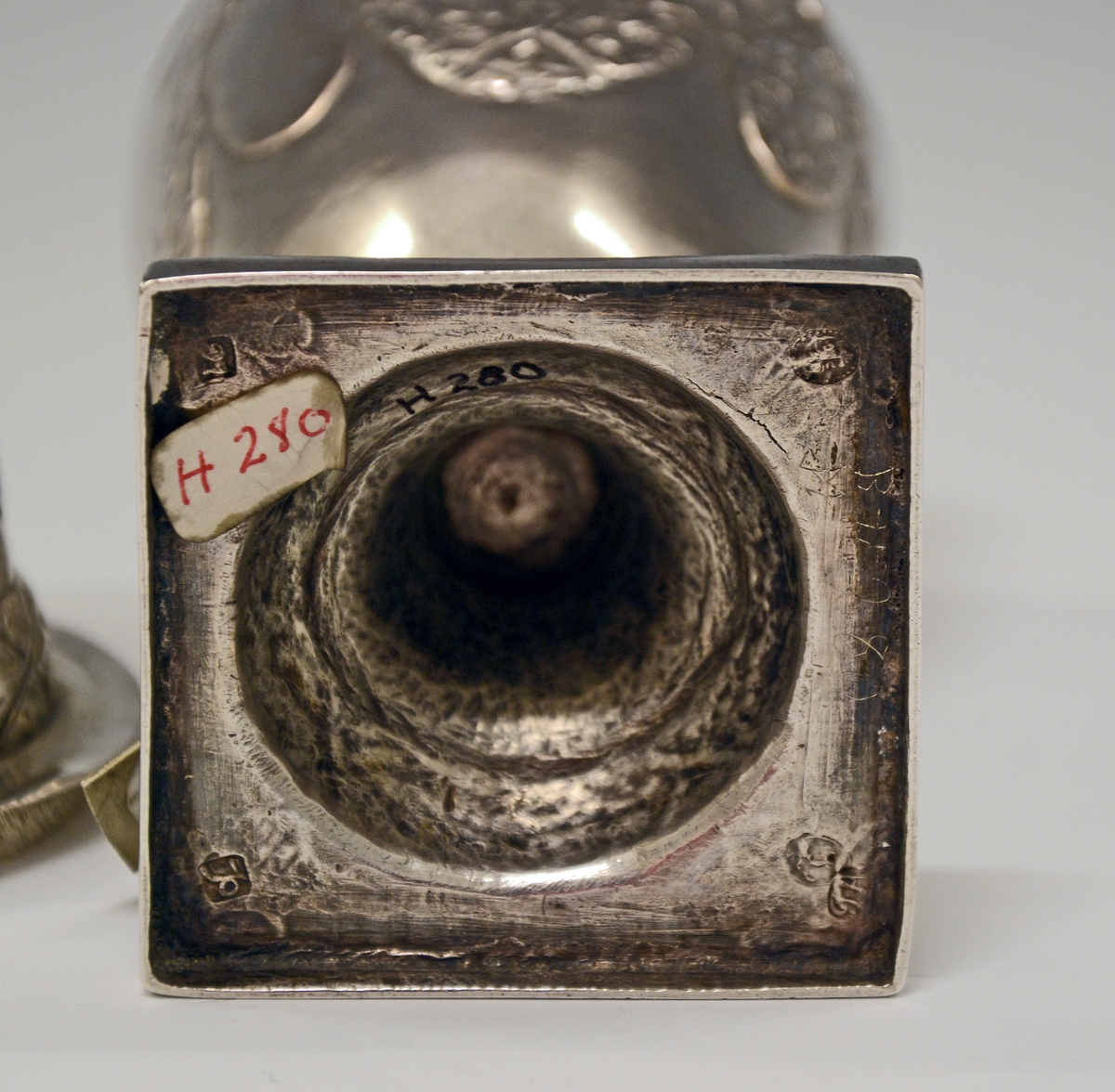 Fra protokollen: Sukkerdrysse av sølv, urne form, Ludvig 16. stil. Stemplet synes at være Kristiansands bystempel.

Oppført som sukkerdrysse i protokollen, men kan det være en "sanddrysse" - for fjerning av overflødig blekk ved bruk av fjærpenn og blekk?