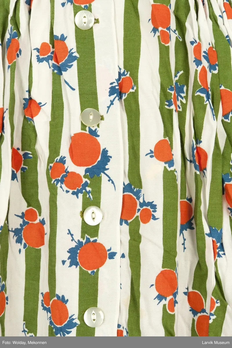 Trykket motiv med grønne striper og oransje "frukter" med blå blad og stilk