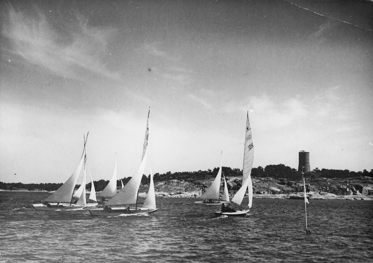 Från starbåtarnas uttagningsseglingar i Sandhamn 21 juni 1936 till OS-seglingarna i Kiel i augusti. Svenska Seglarförbundet hade uppdragit arrangemanget av dessa uttagningsseglingar åt KSSS. De båtar som kan identifieras på bilden är Daniel Sundén-Cullbergs 915 SUNSHINE i förgrunden t v samt Dag Sundén-Cullbergs 1014 MOONSHINE längst t h.