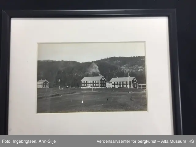 Seks rektangulære rammer med glass. Rundt hvert bilde er det et hvitt paspartoute. Midt på rammens overside er det skrudd fast et rundt oppheng. 
Bilde A: En sykepleier i uniform.
Bilde  B: To sykepleiere i uniform.
Bilde C: En gruppe mennesker som ligger i gress.
Bilde D: En gruppe damer og barn som sitter i gress.
Bilde E: En gruppe ansatte utenfor bygningen.
Bilde F: Oversiktsbilde av Jansnes.