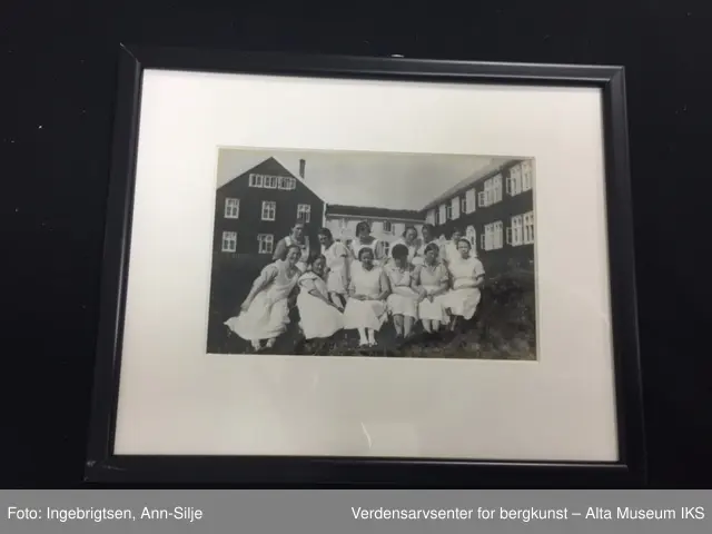 Seks rektangulære rammer med glass. Rundt hvert bilde er det et hvitt paspartoute. Midt på rammens overside er det skrudd fast et rundt oppheng. 
Bilde A: En sykepleier i uniform.
Bilde  B: To sykepleiere i uniform.
Bilde C: En gruppe mennesker som ligger i gress.
Bilde D: En gruppe damer og barn som sitter i gress.
Bilde E: En gruppe ansatte utenfor bygningen.
Bilde F: Oversiktsbilde av Jansnes.