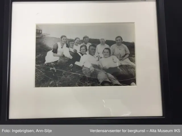 Seks rektangulære rammer med glass. Rundt hvert bilde er det et hvitt paspartoute. Midt på rammens overside er det skrudd fast et rundt oppheng. 
Bilde A: En sykepleier i uniform.
Bilde  B: To sykepleiere i uniform.
Bilde C: En gruppe mennesker som ligger i gress.
Bilde D: En gruppe damer og barn som sitter i gress.
Bilde E: En gruppe ansatte utenfor bygningen.
Bilde F: Oversiktsbilde av Jansnes.