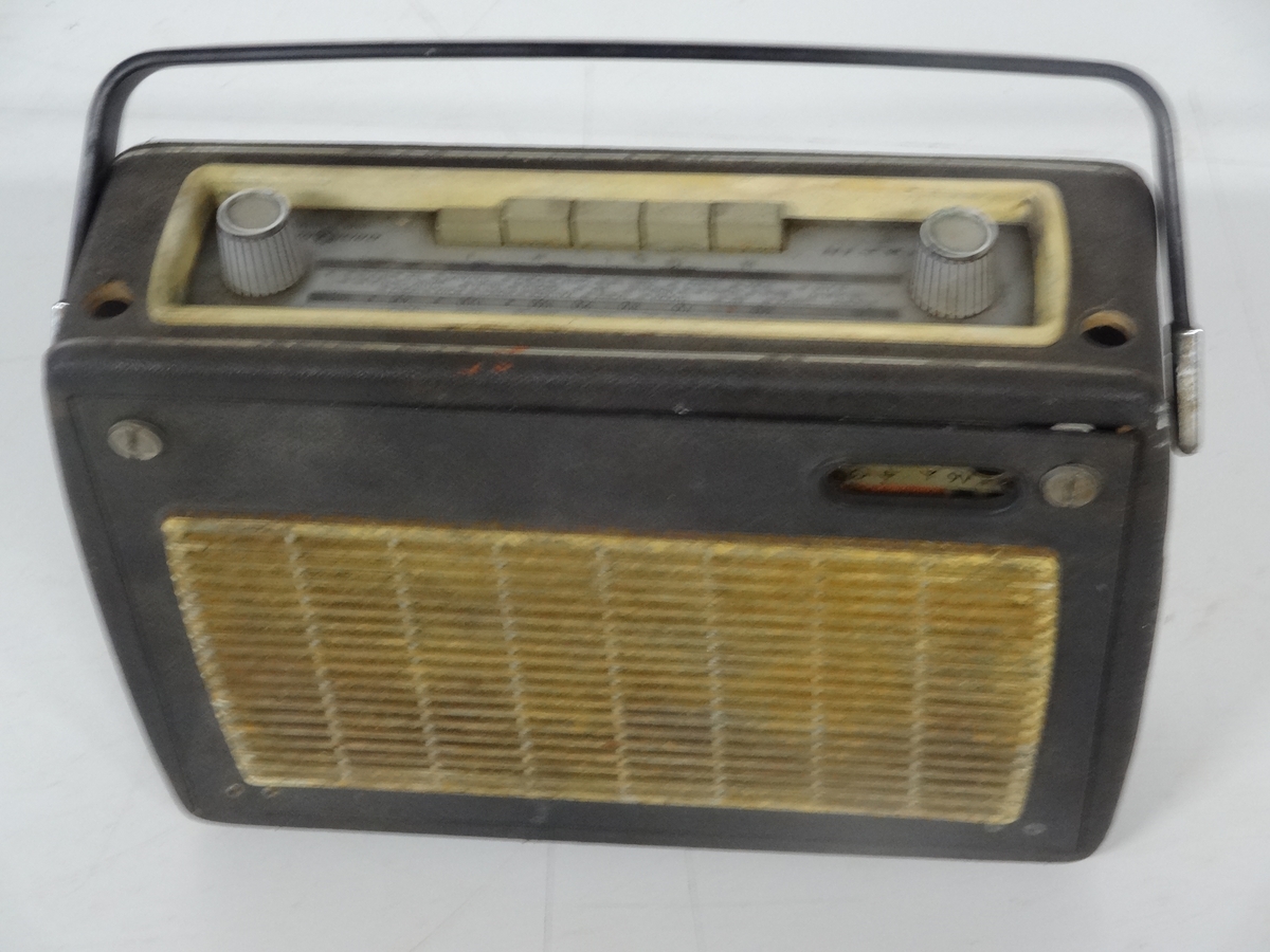 Transistorradioapparat fra Radionette av type Kurér med tilleggsbetegnelsen "Marine deluxe". 

Radioen har merker på undersiden som forteller at den kostet 590 kr og hade en stempelavgift på 47,50 kr. Apparatet fungerer ikke.  Det er og mulig å koble til båndspiller / grammofon.

Batteri er borte.