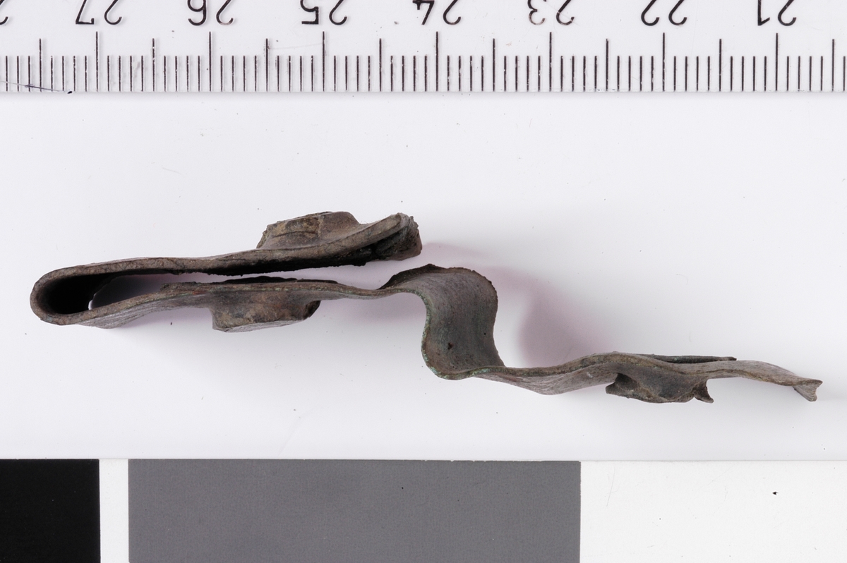 MÅL: L. 65 MM  B. 19 MM, LANG, REKTANGULÆR BRONSEPLATE MED TRE NAGLER PÅ PLASS. BØYD.