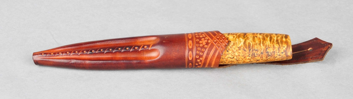 Handtaket er av olja valbjørk, utan holkar.Smidd blad med stempel. Slira er sauma kant i kant. Dekoren er trykt og pauta.
