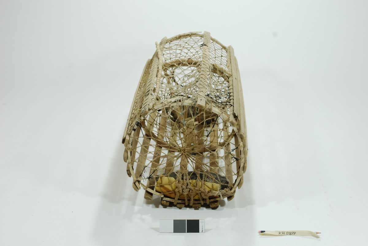 Moderat stor sylindrisk tene med en inngang i kortsiden. Kombinasjon av sprøtt- og vartene. Midterste gjordering av ener, de to ytterste trolig av ek. Har fangstkammer. Begge kalver (både ytterkalv og blindkalv) har sylindriske ringer. Kokostau benyttet i garnbusen i lokkeåpningen , fibrene meget slitt. Egenprodusert garn innsatt med linolje?, blir mer bestandig og stivere. En ekstra lekt spikret utenpå den listen hvor garnbuset er festet. Agnspyd i tre. Tradisjonell lukkeåpning med garn og håndsnittet tverrpinne/ lukkepinne som er ekstremt lang. Ekstra meier i bunnen for stabilitet ved bunnleie. Sikre spor etter tjæring/barking, men meget slitt. Synkesten av granitt. Skrapsten bundet fast med gresstau.  Ved kalveåpningen i enden synkesten av rullesten. Bundet fast med gresstau. Gummi/ regntøy-lerret mellom sten og garnbus for å hindre slitasje. Garnbusen flere steder bøtet på. Benyttet sort syntetisk tau. Spikerne rustet. Endel modifikasjon/reparasjon ved slitasje/skader.