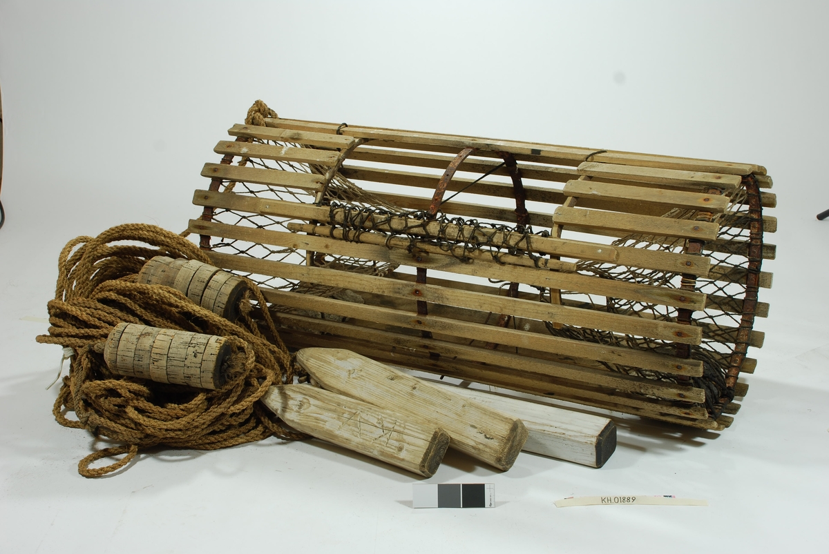 Rund/ sylindrisk sprøtt-tene. Hjemmespunnet garn med store masker. To motstående innganger i kortsidene. Intet fangstkammer. Kalveringer i metall, ovale i formen tilpasset krabbens fasong. Ovalformet åpning i toppen forsterket med ubehandlede barkkledde enerkvister som er formet til. Metallgjorder virker solide og kan være spesiallaget. Agnspyd i metall horisontalt plassert med ekstra sperre i kalveringen. Synkestener i granitt i hver ende, bundet fast med sort tauverk. Åpning med gammeldags lukkepatent med garn og håndspikket pinne. Tena bærer preg av tidligere å ha vært tjæret/ barket. 

Store mengder gresstau og fem væler, tre stk. i treverk og to stk. av kork. 
Hvitmalte trevæler i tre størrelser:
Størst: 63x9 cm.
Mellomst: 51x9 cm. 
Minst: 41x9 cm.
Alle har profilerte kanter og er hvitmalte med sort ende (tjæret). Malingen er nesten slitt av. K.V er skåret inn i de tre fløtene.
Korkvæler:
Lengde: 22cm
Omkrets 32 cm.
K.V risset inn i den ene.