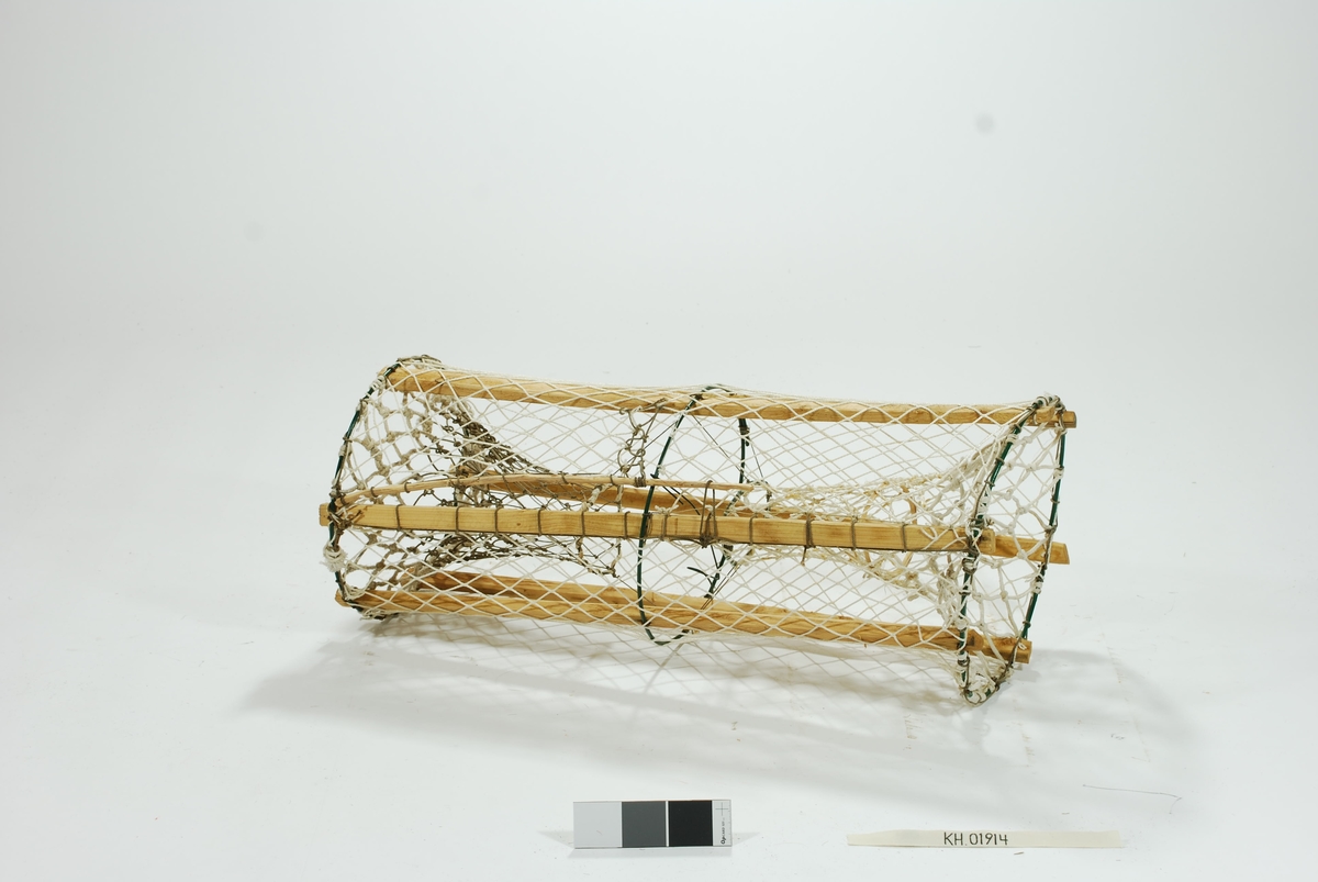 Laget som leke til barn. Sylindrisk sprøtt-tene med to motstående innganger. Seks grove spiler i forskjellige trematerialer. Tre gjorderinger i metall. Intet fangstkammer. Kalveringer i vidjebånd og metall. Ulikge garntyper i syntetisk materiale, store maskehull. Ingen synkestener, tau eller væler. Gammeldags lukkeåpning med håndskåret pinne.