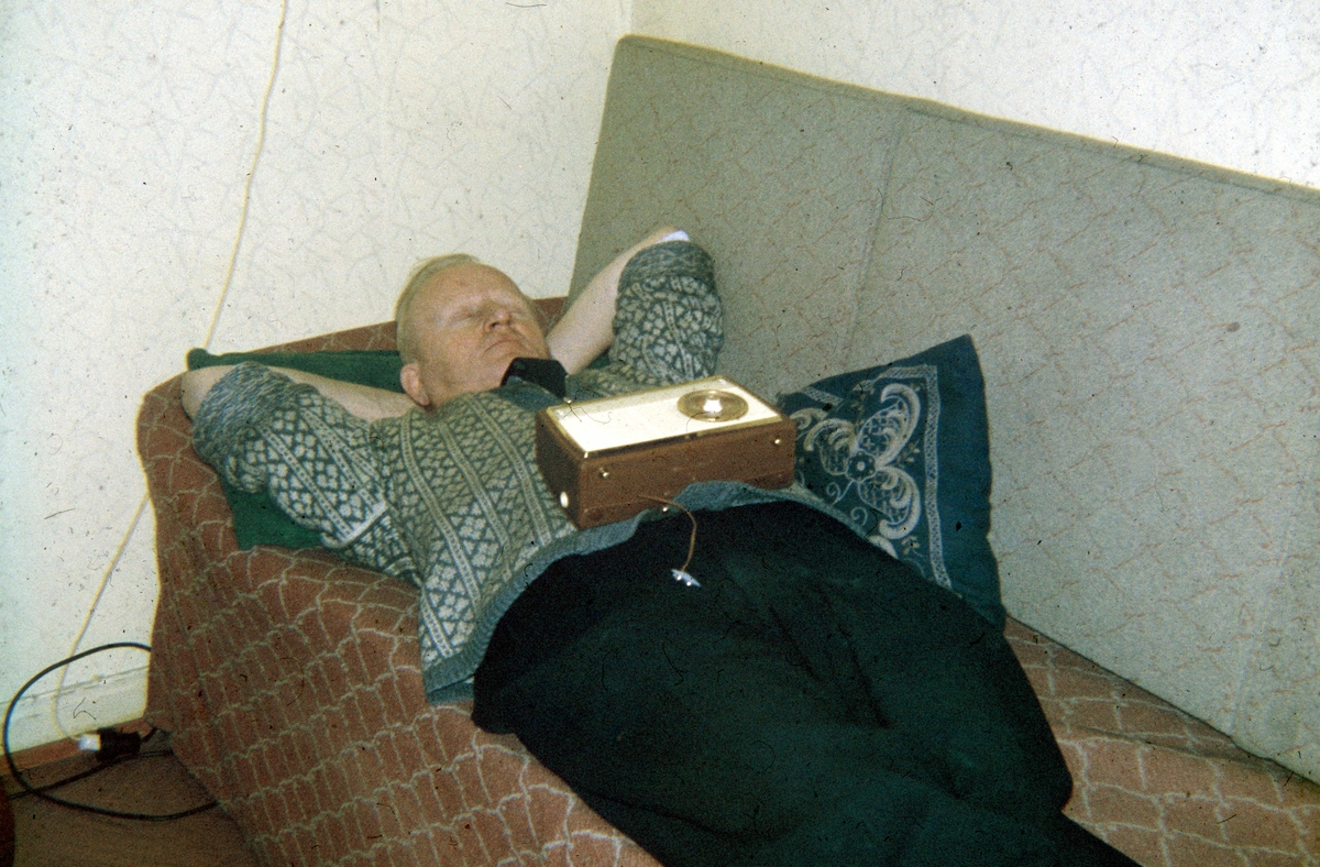 En mann sover middagslur på divanen med transistorradio på magen, Bjerregaards gate 29, Oslo, 1964