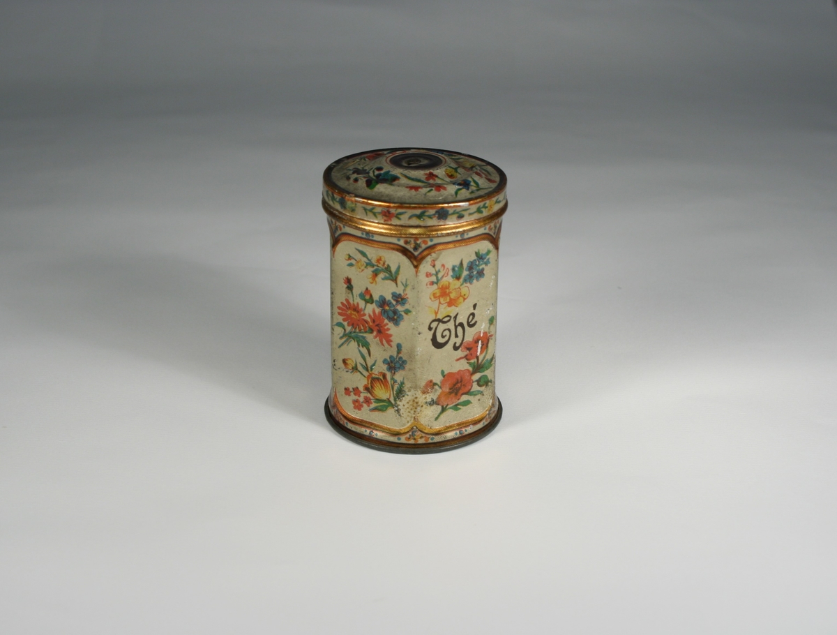 Montasje med 5 foto av Elias Tønnesen på en plate. Platen med bilder og tekst har nederst en påfestet plate for utstilling av "lykten", som er en sekskantet teboks, dekorert med blomster, og med to små hull for lyset. Teboksen inneholder en talglysstump.