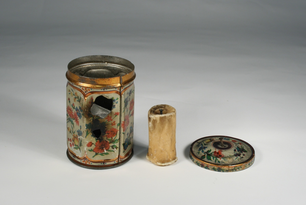 Montasje med 5 foto av Elias Tønnesen på en plate. Platen med bilder og tekst har nederst en påfestet plate for utstilling av "lykten", som er en sekskantet teboks, dekorert med blomster, og med to små hull for lyset. Teboksen inneholder en talglysstump.