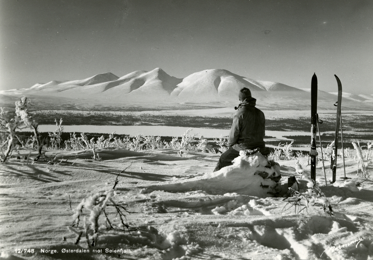 En mann på skitur tar en røykepause.