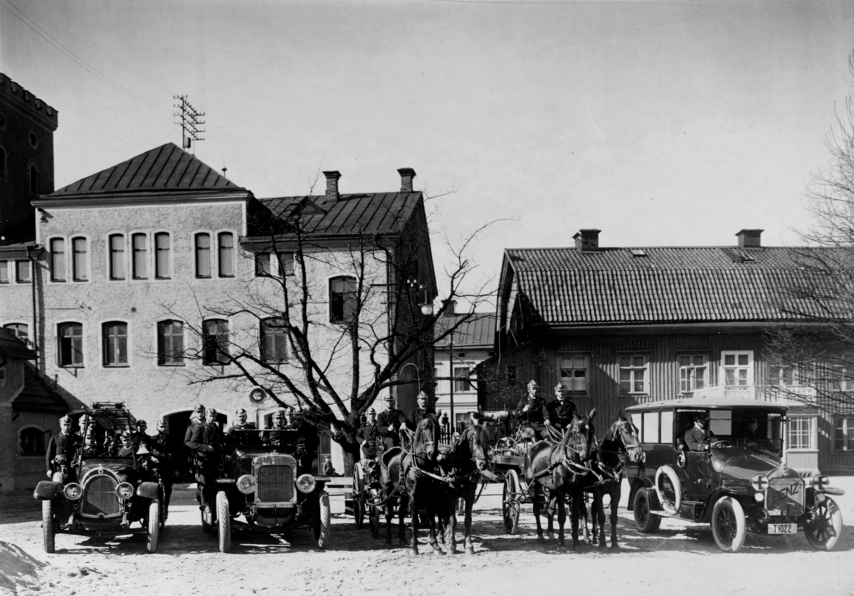 Örebro Brandstation, brandbilar och brandmän, hästar och vagnar.
Från höger Fabriksgatan 9, 11. Huset till höger brandchefens bostad. 
Brandbilen längst till vänster är en 50 hästkrafters Scania-Vabis Typ III som hade reg.nr. T214. Bredvid står en 40 hästkrafters Nash brandbil som hade reg.nr. T1038. Längst till höger står en ambulans av modell Benz 18/30 PS som hade reg.nr. T1022.