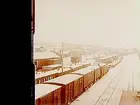 Järnvägsstation i Jämtland eller Ånge, Medelpad. Rangerbangård, godsvagnar och öppna vagnar.
Stereofotografi.