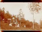 Sommarstugan Fridensborg, envånings sommarstuga med inredd vind och veranda. Fem barn och två vuxna framför stugan, 2 getter.
Fotograf Sam Lindskog