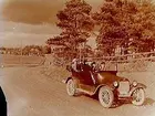 Öppen bil av märket Chevrolet, sex personer i bilen.
John Johansson. 
Bilen är en Chevrolet modell 490 från 1921. Den registrerades den 30:e juli 1921 med registreringsnummer T1277 och ägdes av S. H. Gustafsson och John Einar Johansson i Almby. År 1930 fanns den fortfarande i trafik, numera ägd av enbart John Einar Johansson i Almby.