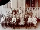 Rynninge folkskola, 21 skolbarn med lärare fröken Dahlstedt.
Skolbyggnad i bakgrunden.