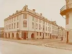 Trevånings hyreshus med butikslokaler. 
Hörnfastigheten Ekersgatan och Tulegatan.
Byggmästare Axel Moberg.