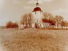 Stora Mellösa kyrkan. I förgrunden gravhög.
Beställningsnr: SM-132.