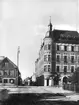 Stenhus i tre och fyra våningar med livfull tornprydnad, K.F.U.M. huset.
Storgatan mot söder från Järnvägsgatan.
Bilden är troligen en reproduktion (1934) efter en bild från ca 1903, tagen av fotograf Axel Barr.