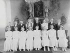 Interiör av Vintrosa kyrka.
Konfirmander, 10 flickor, 5 pojkar och kyrkoherde Erhard Morén.