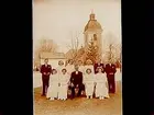 Konfirmander, 8 flickor, 3 pojkar och pastor Persson.
Pingstdagen 1942.
Rinkaby kyrka i bakgrunden.