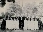Kils kyrka i bakgrunden.
Konfirmander, 8 flickor, 12 pojkar och kyrkoherde Skjöldebrand.