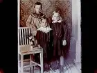 Rumsinteriör, tre barn vid en stol.
O.A. Wistrand