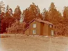 Bostadshus, en kvinna framför huset.
Sam Lindskogs familjebild.