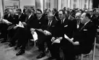 Sträng invigde (2) 1 december 1967

Socialdemokraternas Gunnar Sträng inviger något och sitter omgiven av andra herrar på en stol i en stor sal. Han är klädd i svart kostym, vit skjorta, svart slips, svarta skor, svarta strumpor samt bär glasögon.