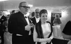 Teatergalan III den 1 mars 1965.

Uppklädd galapublik i foajén på Hjalmar Bergmanteatern. I förgrunden: en dam och en herre.