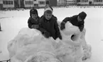 Snögrottor, 4 december 1965.

Man varnar för 'farliga snögrottor' i snöhögarna från snöplogarna. Här bygger barnen en snöfästning på stora cementrör på en fyrkantig innergård omgiven av hyreshus. I bakgrunden snötäckta gungor.