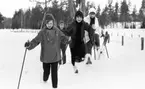 Hästnäs, 20 januari 1966

På bilden syns det fyra flickor som är klädda i vinterkläder och som åker skidor. Marken är täckt med snö.