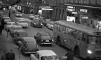 Julrusch, 24 december 1965

Bild av norra delen av Drottninggatan mot Storbron. Granrisgirlander med lampor och julprydnader i form av gula stjärnor och röda klockor hänger i bågar tvärs över gatan med ca 10 m avstånd mellan. trottoarerna är fyllda med folk.