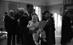 Barn på konstutställning 12 april 1966

En baby sitter framåtvänd mot sin pappas mage. Mannen har babyn i en bärsele. Runtomkring syns damer och herrar. Herrarna är klädda i kostymer. Tavlor hänger på väggarna i rummet. De befinner sig på en konstutställning.




















































































































or. Han går nedför en kort trappa utomhus.