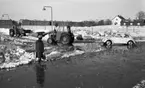 Snömodd och översvämning, 1 februari 1966
Bil, traktor och kvinna i vattensamling på vintrig gata