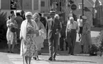 Loka brunn 2 22 juli 1966

En massa äldre damer och herrar på promenad i kurorten Loka brunn. En av damerna sitter i en rullstol. Damerna bär klänning och herrarna bär kostym. I bakgrunden syns byggnader samt bilar.