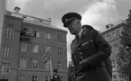 Kungen I3 28 augusti 1967

Närbild på kung Gustav VI Adolf som besöker Örebro Livregementes Grenadjärer i Grenadjärsstaden. I bakgrunden syns en militär med befälsbricka runt halsen och en fana i handen. Uppe på regementsbyggnadens balkong står ett antal kvinnor och män och betraktar kungen som är tillsammans med militärerna nere på regementsgården.
