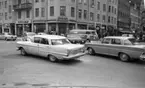 Rubrik till negativbilderna: Skyddsrep (fort). 13 april 1967. 
Järnvägsgatan, Storgatan. 
En svart och en vit Opel Kapitän.