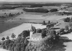 Flygfoto över Hackvads kyrka, bostadshus och byggnader.