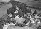 Flygfoto över Håkanbol, bostadshus och ekonomibyggnader.