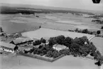 Flygfoto över Runnaby gård, bostadshus och ekonomibyggnader.