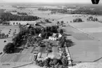 Flygfoto över Ervalla, bostadshus och ekonomibyggnader.