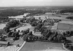 Flygfoto över Snavlunda, kyrkan, bostadshus och byggnader.
Bilden tagen för vykort.