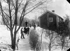 Vinterbild, barn med sparkstötting, bostadshus.
Gamla Norra Hyddan. Här drev Jonas Ohlsson diversehandel. Gustaf Ferdinand Hallberg köpte gården med diversehandeln den15 september 1895.