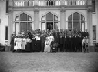 Ett stort gruppfoto vid Boo slot. Längst fram sitter Hugo Hamilton med blombukett, bredvid hustrun Ebba Hamilton. Bakom dem står sönerna Carl Hamilton och Hugo Hamilton, med sina fruar Märta Hamilton, respektive Greta Hamilton.