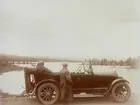 Bilen och herr Larsson i förgrunden. 
Bilen är en Oldsmobile modell 30 från 1923-24 med en 42 hästkrafters sexcylindrig motor. Den registrerades den 2:e april 1924 på fröken Jenny Larsson, Örebro, och fick registreringsnummer T99. År 1930 ägdes den fortfarande av Jenny Larsson.