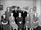 Rumsinteriör, familjegrupp nio personer.
Fotografiet föreställer fru Anna Larsson (född Nors) och hennes åtta barn. Troligen taget vid hennes 70 års dag 14 januari 1951.
Stående från vänster:
Orvar Larsson född 1913, Rune Larsson, brodern Alfred Larsson, Dalie Larsson, gift Karlsson
Sittande från vänster:
Svea Larsson, gift Eriksson, Göta Larsson, gift Hedén, Fru Anna Larsson född Nors, Märta, Ella Larsson, gift Uhlan. 
Fotografen Knut Borg var vän med Orvar Larsson.