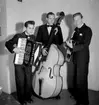 Swing-trio, tre män med musikinstrument (dragspel, bas och gitarr). Sven Charlies Ensemble, Örebro. Fr. v. Sven Charlie Falk, dragspel och piano. Arne Olows, bas. Lasse Karlsson, gitarr och trumpet.