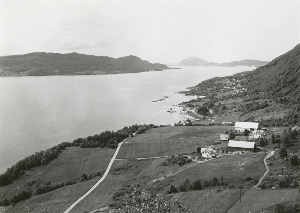 Prospektfotografi av Gryta på Grytestranda med utsikt utover fjorden mot Ellingsøy, Godøy og Valderøy. I forgrunnen ligger en gård.